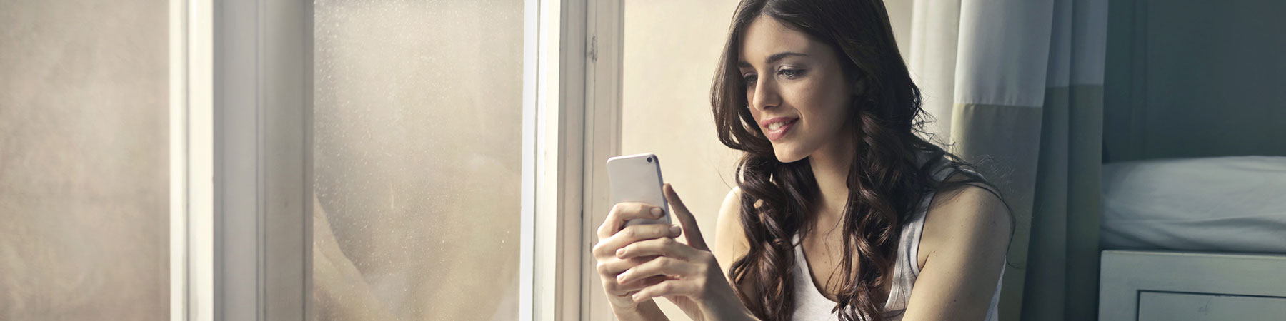 smiling woman looking at cell phone